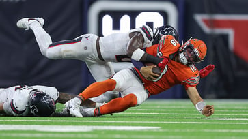 Azeez Al-Shaair punches Roschon Johnson during the game, and Johnson reacts.