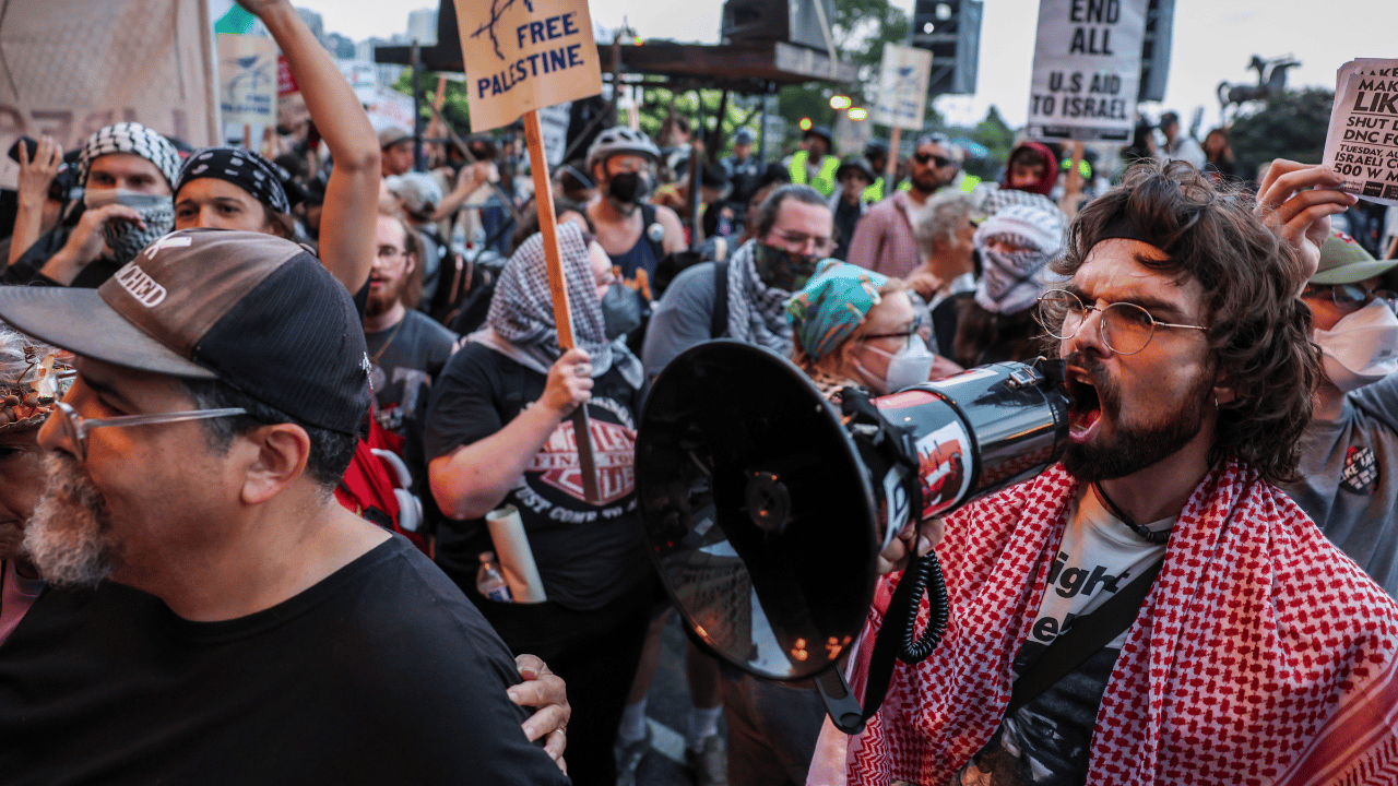 An anti-Israel protester wearing a mask disrupts a delegate party on the eve of the DNC in Chicago.