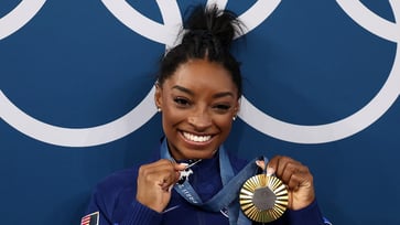 Simone Biles admits that her diamond-studded GOAT necklace is "offensive" to some people.