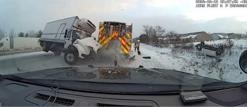 Video footage captured a truck losing control and colliding with emergency vehicles on the side of an icy highway.