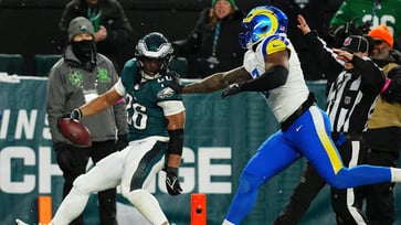 Rams' Jared Verse is left in the dust by Eagles' Saquon Barkley as he scores a touchdown.