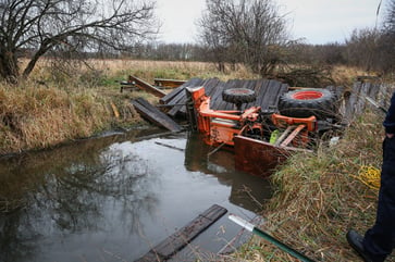 An Illinois man was saved after his tractor became trapped in a creek following a bridge collapse.