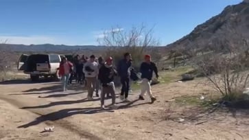 Dozens of migrants were caught on video being delivered to the border before entering the US illegally.