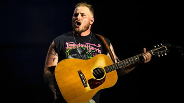 During his concert, Zach Bryan reprimands a fan for tossing an object on stage.