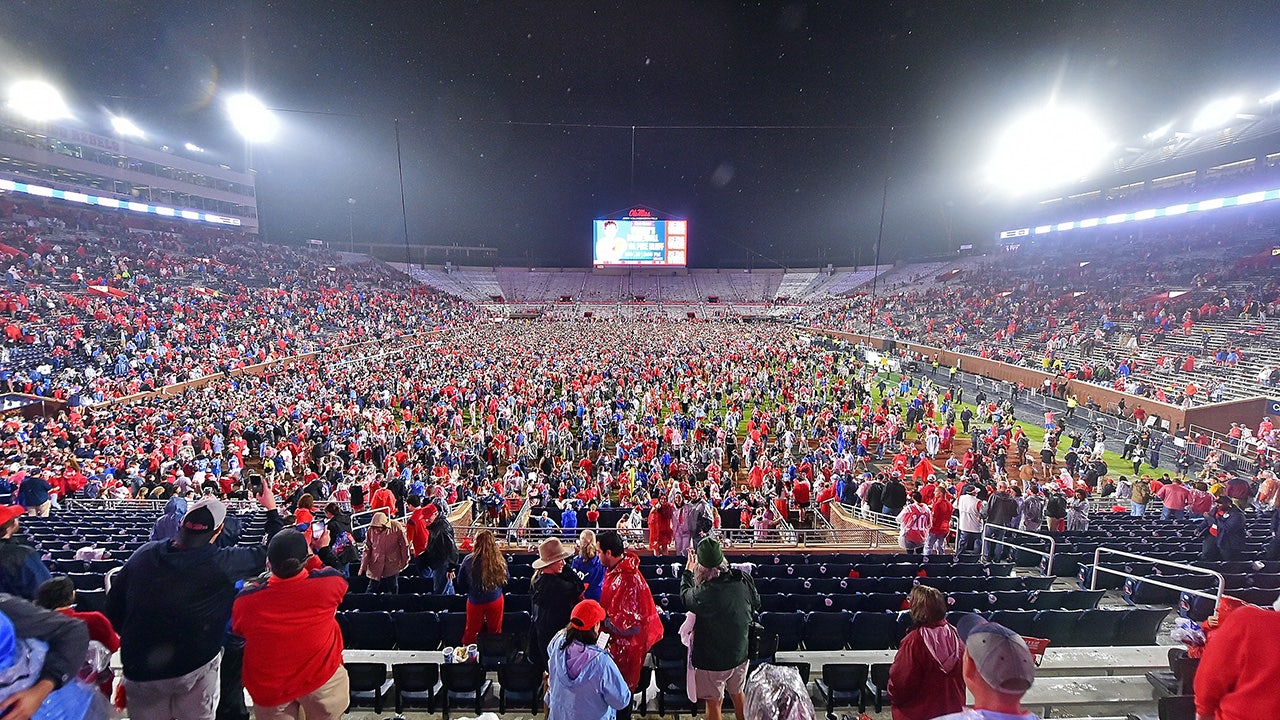 With time remaining on the clock, Ole Miss fans rush the field, causing a delay to the game's conclusion.